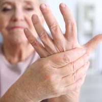 Elderly woman suffering from pain in hand, closeup